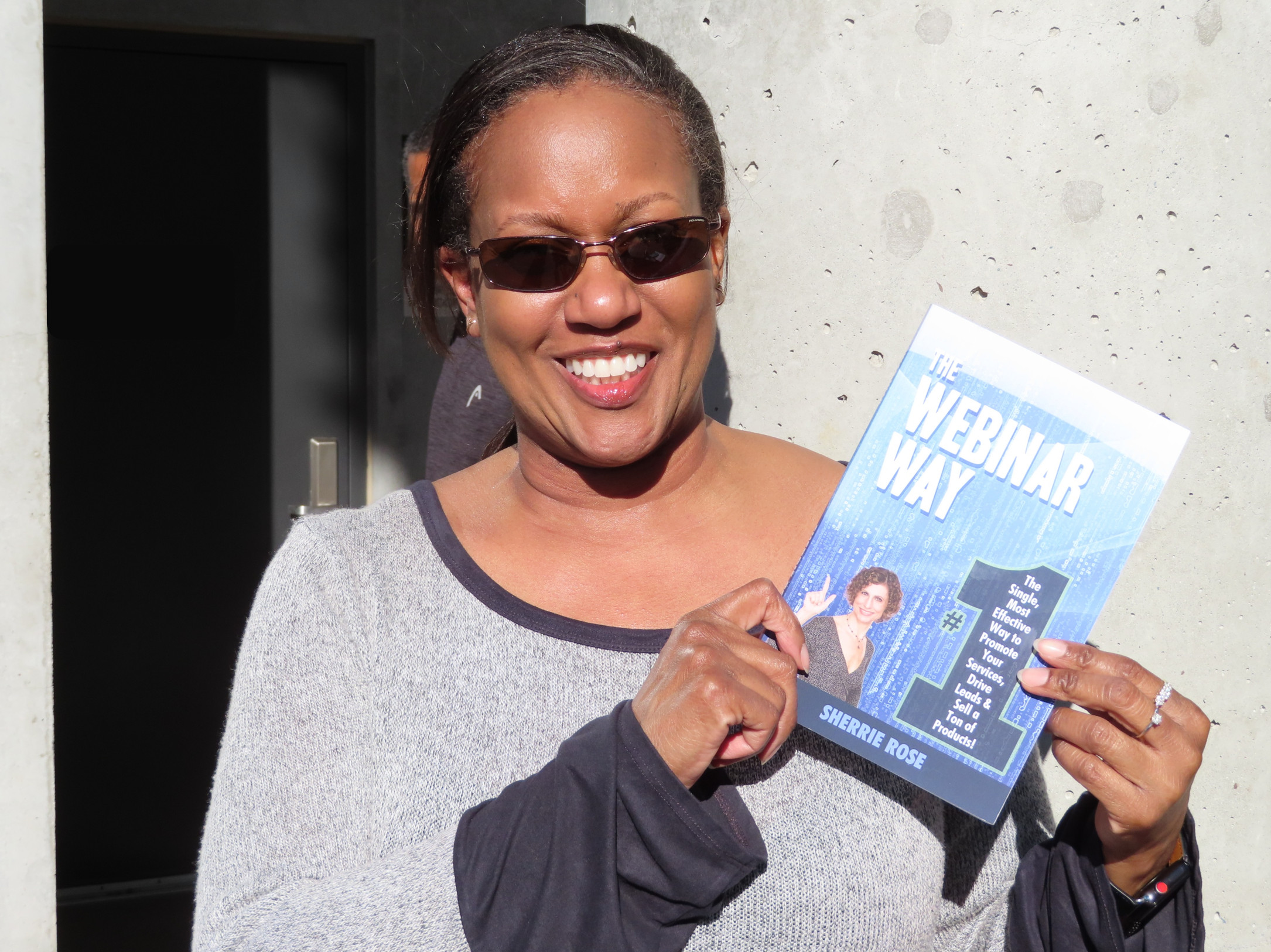 A reader holding The Webinar Way