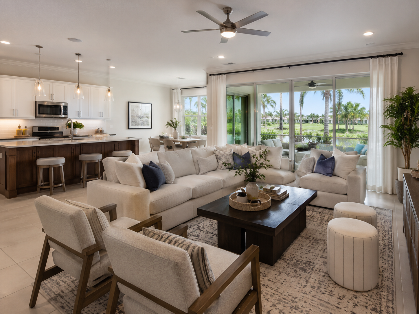 Beautifully staged Lake Nona living room with large windows, natural light, neutral furnishings, and views of tropical landscaping outside.