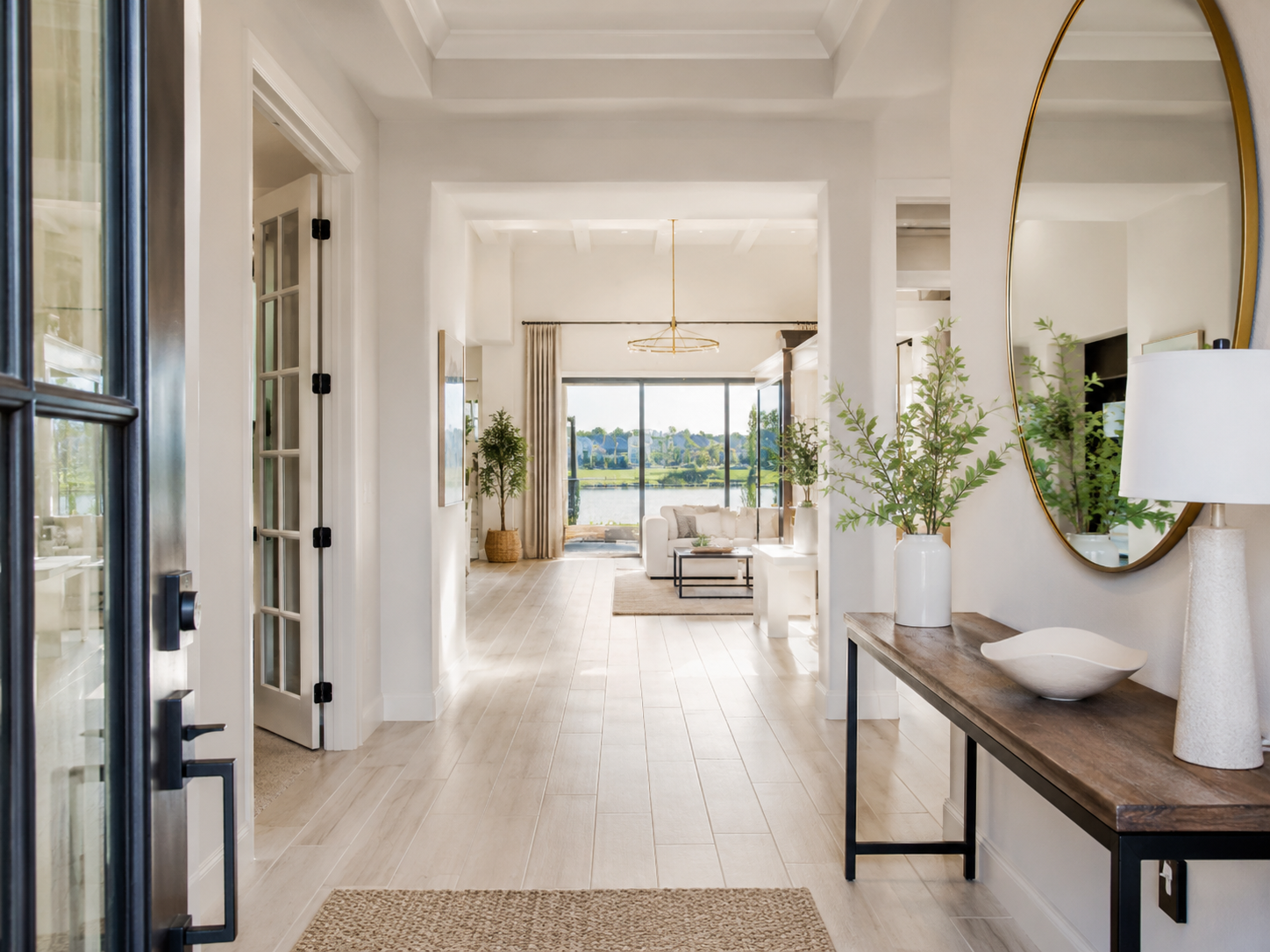 Bright Lake Nona home entryway with natural light, clean finishes, and an open view into a staged living area and waterfront backyard.