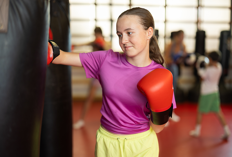 Young-girl-practicing-self-defense-on-a-heavy-bag-in-class Young-girl-practicing-self-defense-on-a-heavy-bag-in-class