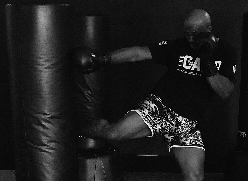 Male fighter demonstrating full hip rotation and core torque on a heavy bag kick in Muay Thai training Male fighter demonstrating full hip rotation and core torque on a heavy bag kick in Muay Thai training