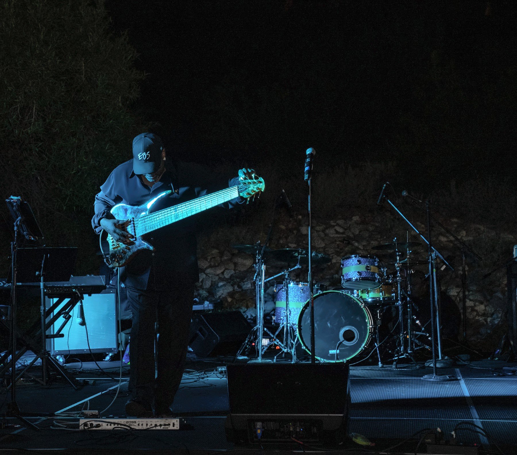 Bassist on a lit stage at a confidential leadership conference