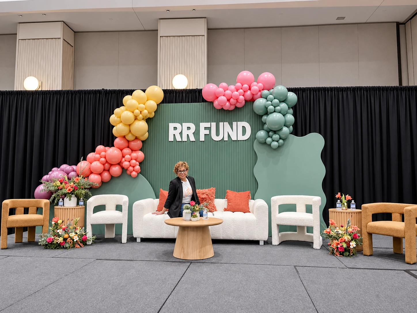 RR Fund stage with green scenic backdrop, balloon installation and full black draping