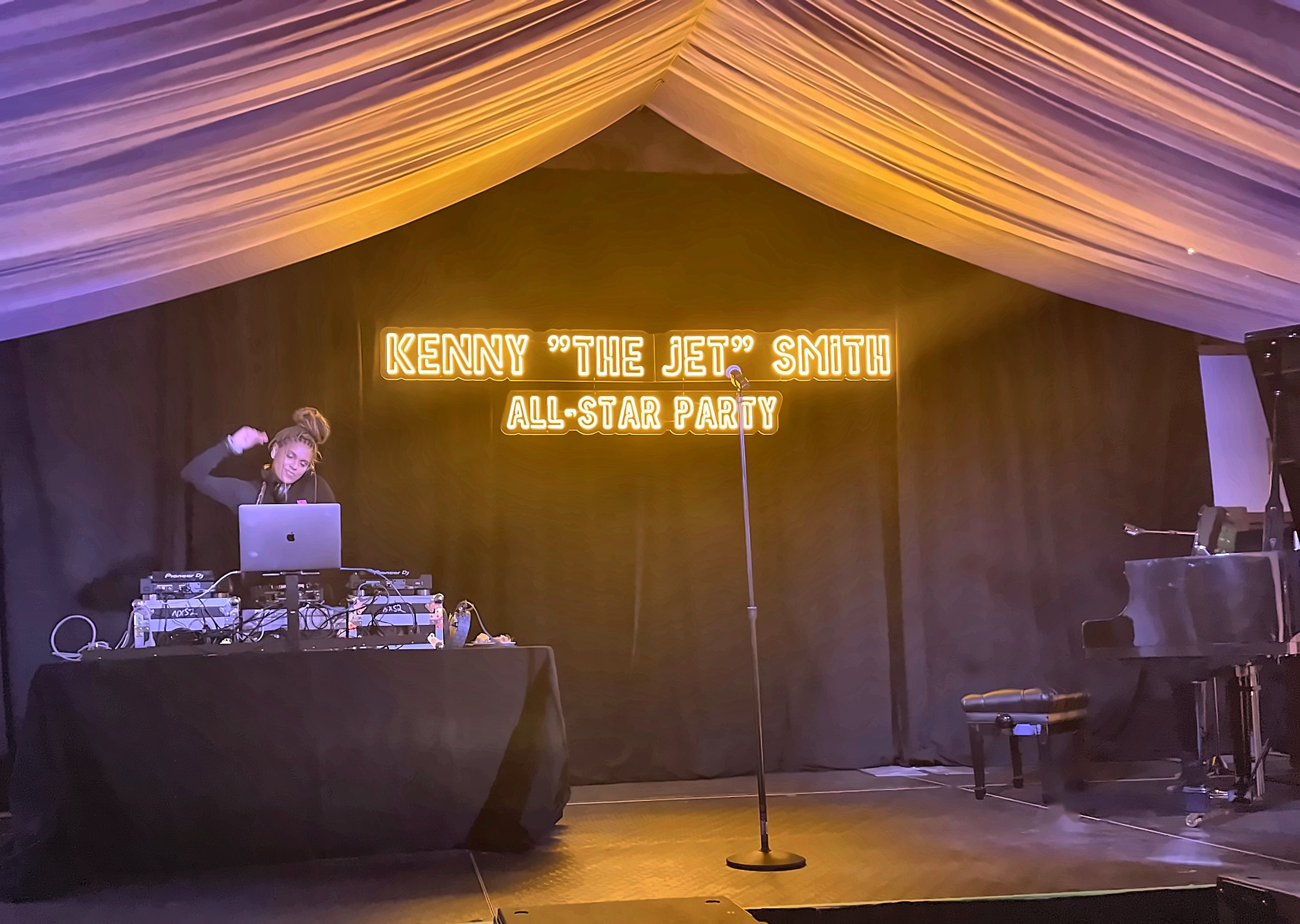 Neon stage and chandeliered tent lounge at an All-Star weekend party