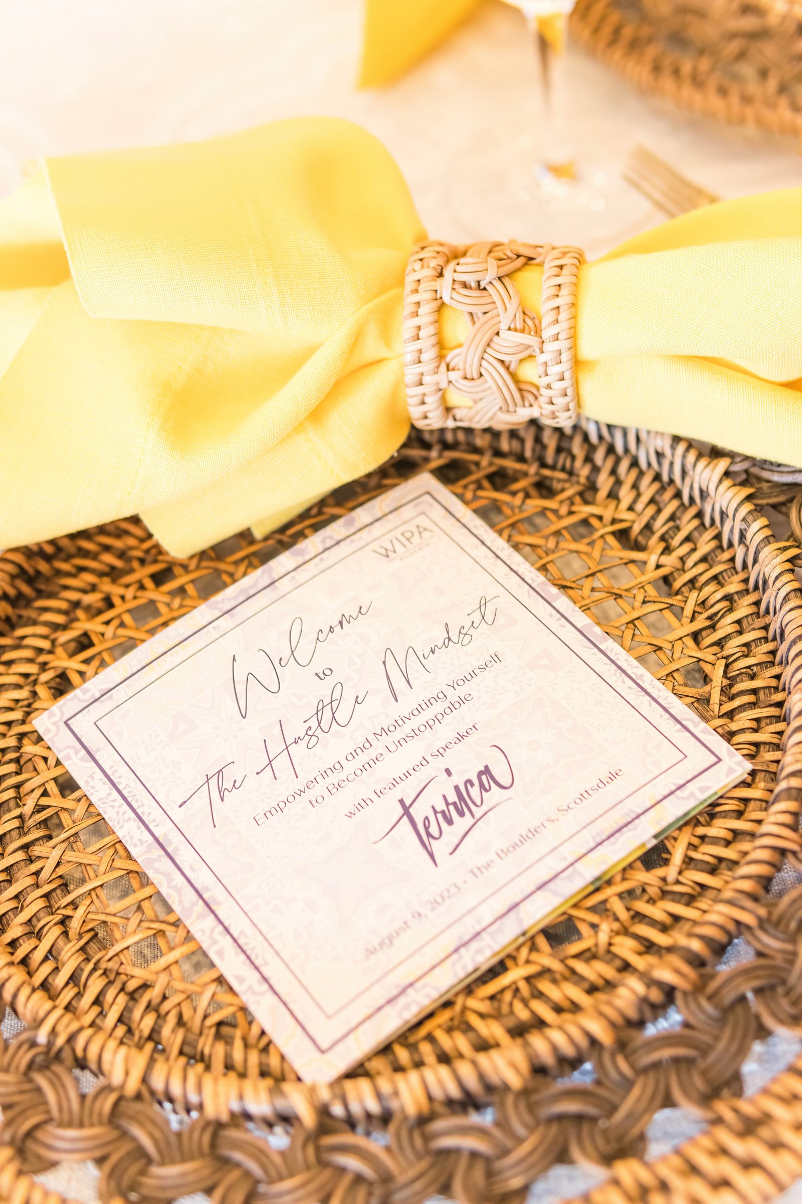 The Hustle Mindset program card on a rattan charger