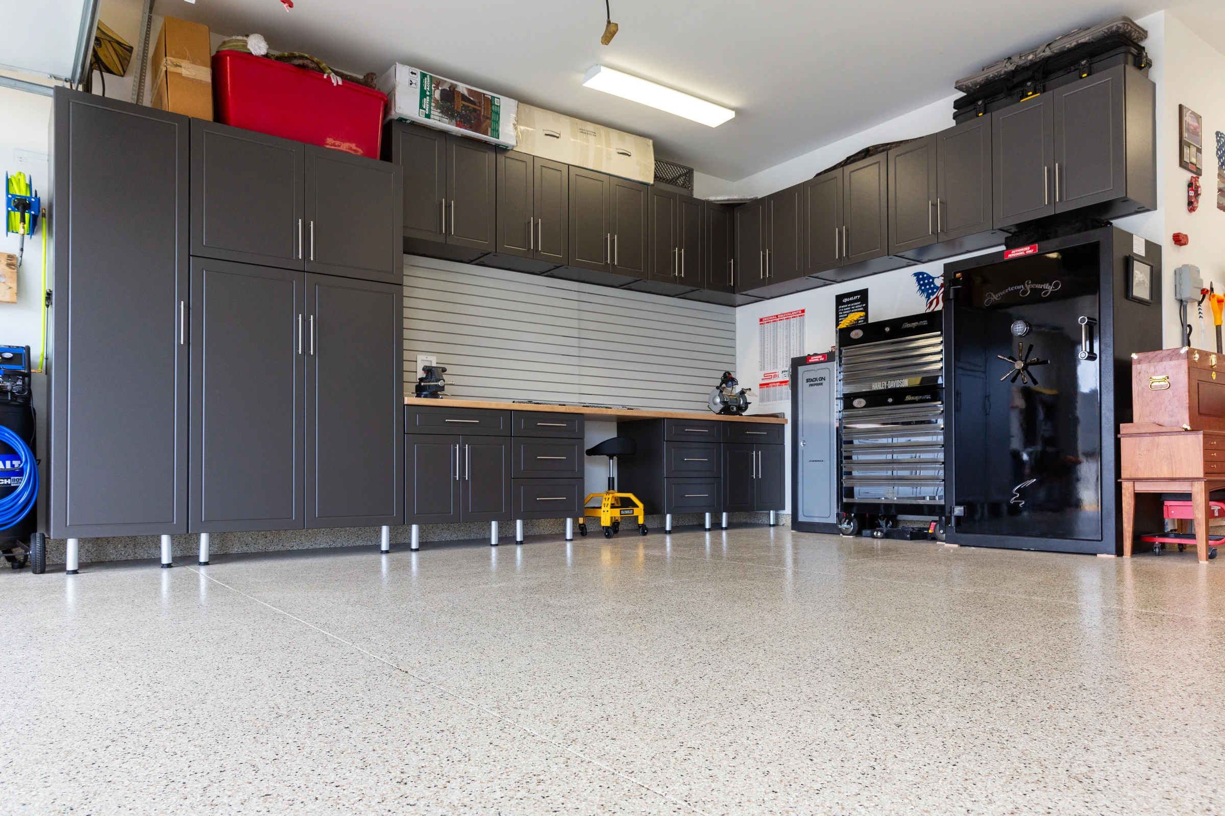 Luxury charcoal garage cabinets with full-height storage, butcher block workbench, and slatwall organization installed by Garage Titan in Boise, Idaho