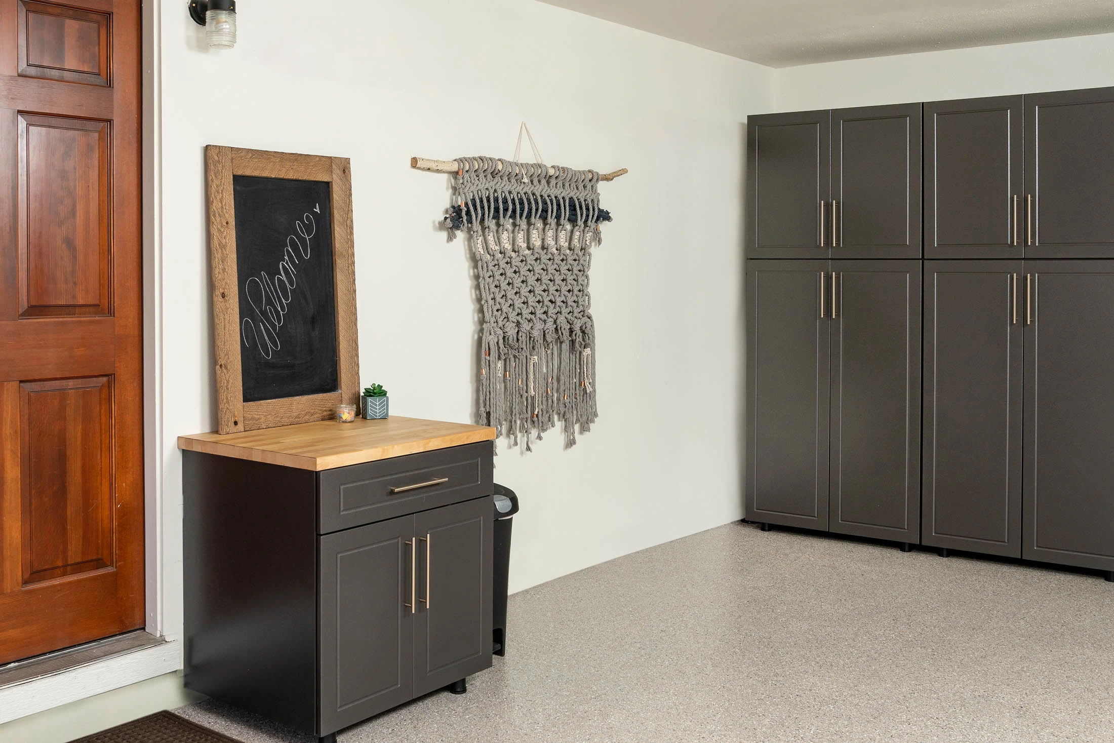 Custom charcoal garage drop zone cabinet with butcher block countertop, full-height storage cabinets, and premium polyaspartic garage floor installed by Garage Titan in Boise, Idaho.