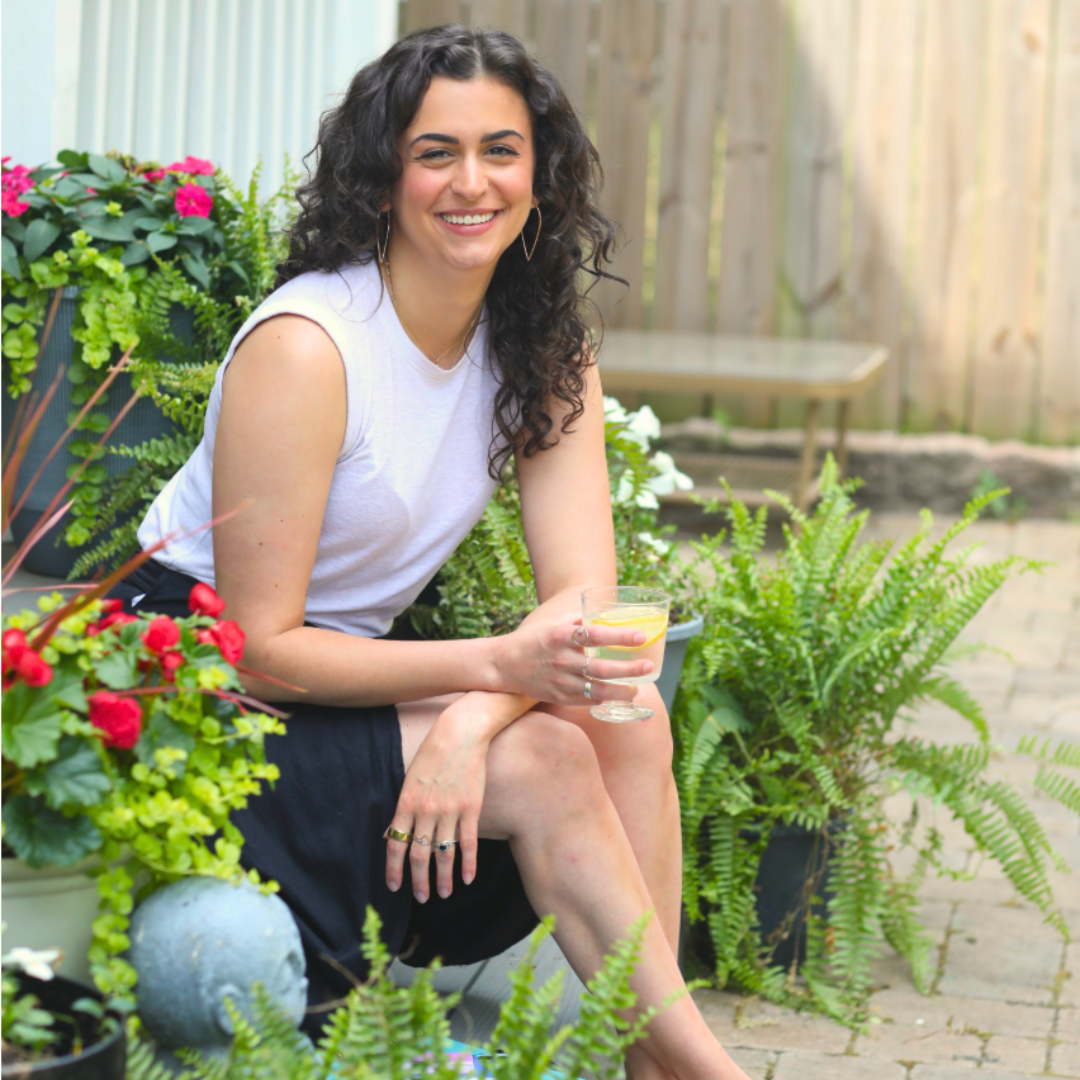 Gabi Day, Hypema'am founder, smiling outdoors among garden greenery
