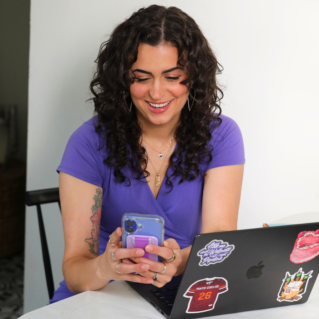 Gabi Day working from her phone and laptop