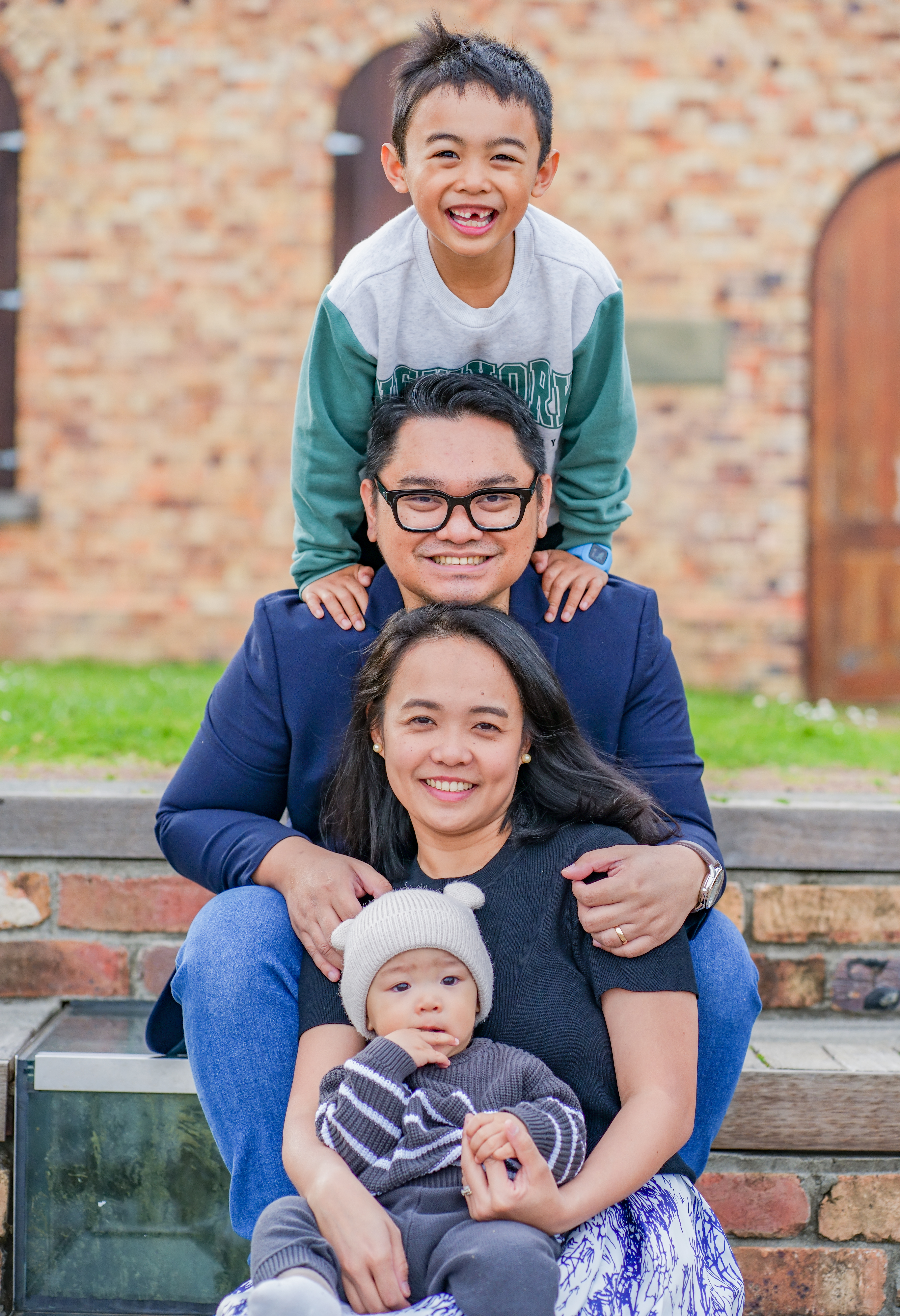 A family of four photographed together on the steps outside