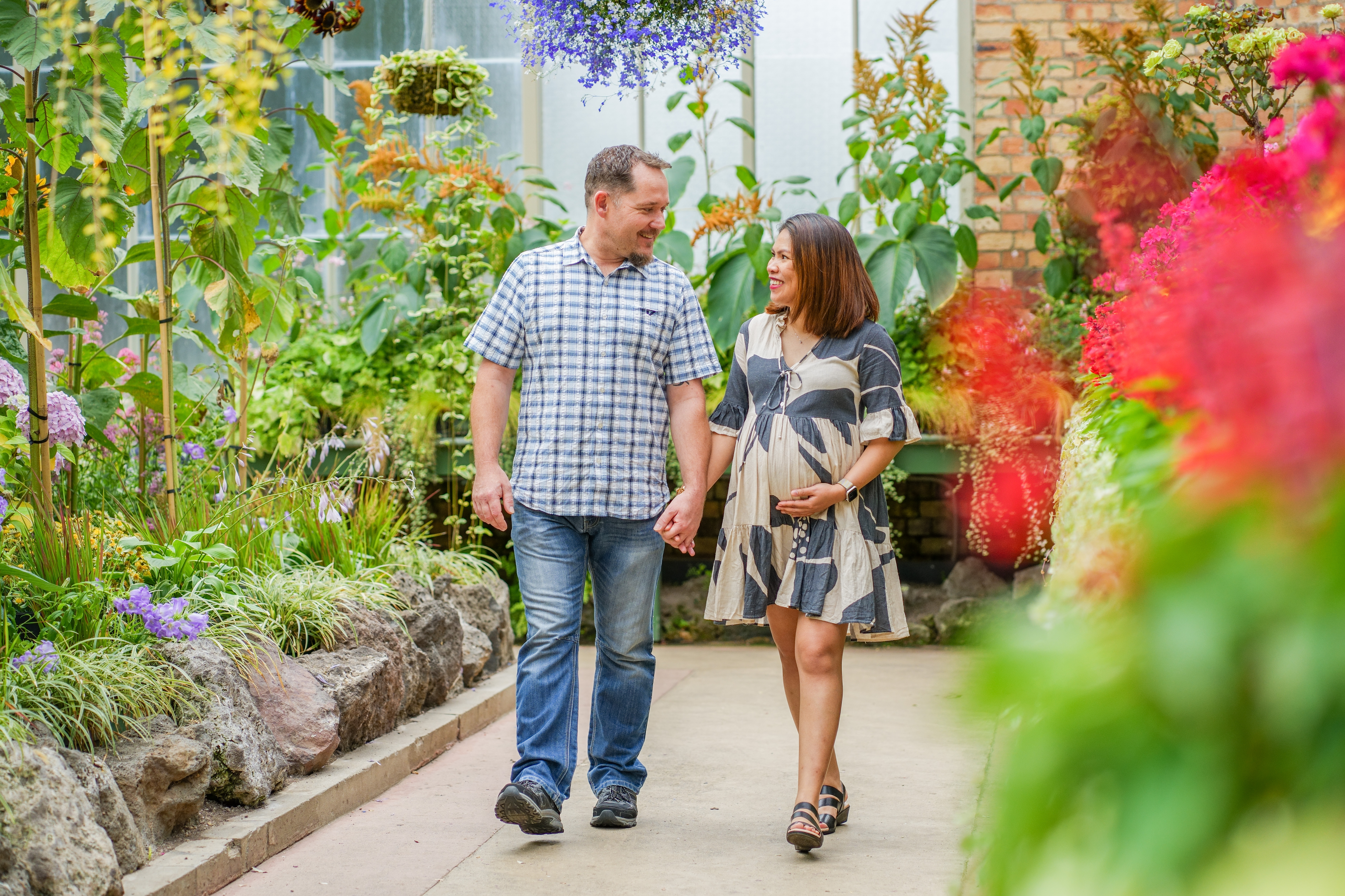 An expectant couple photographed in a garden
