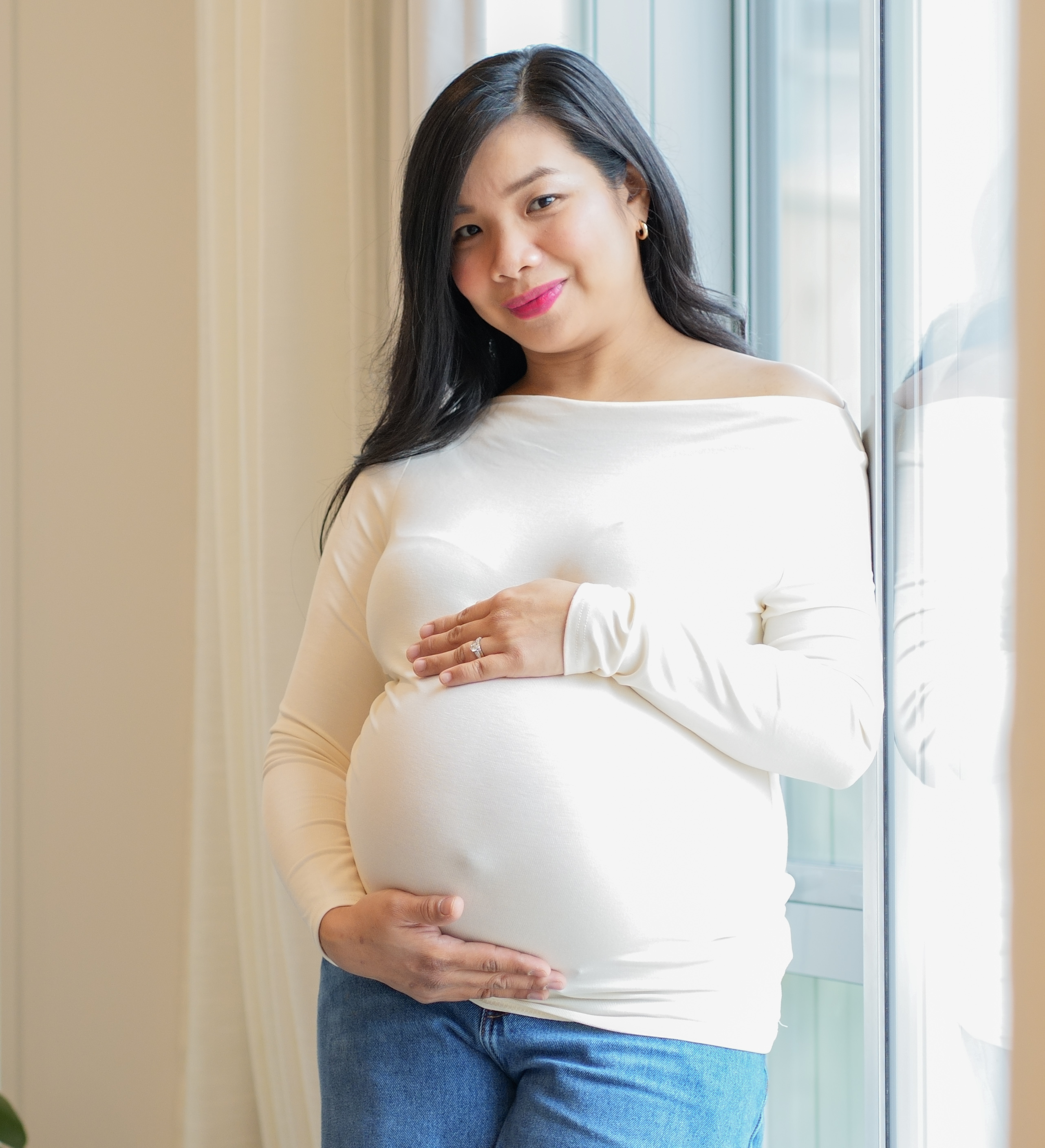 An expectant mother photographed by a window
