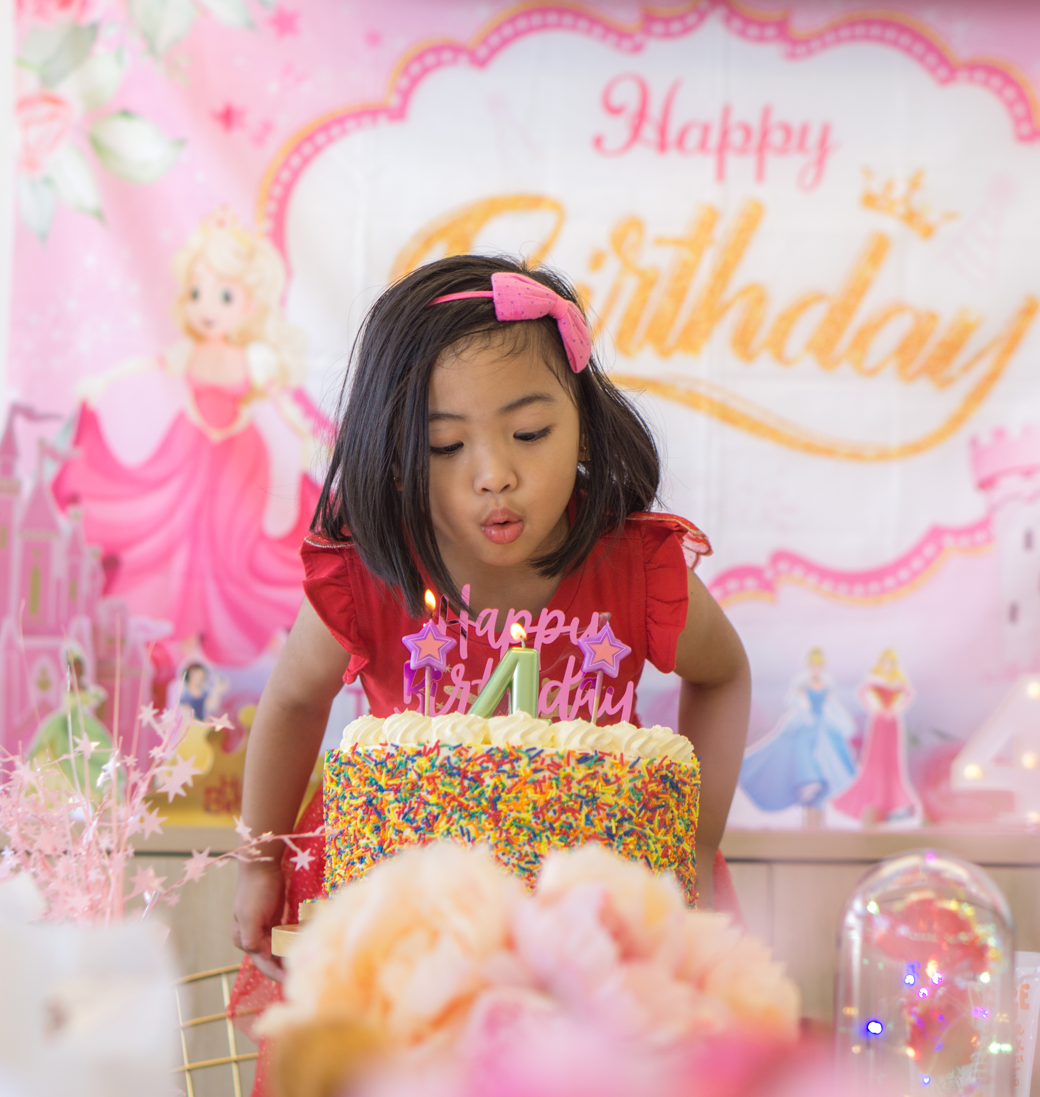 A girl blowing out the candles at her birthday party