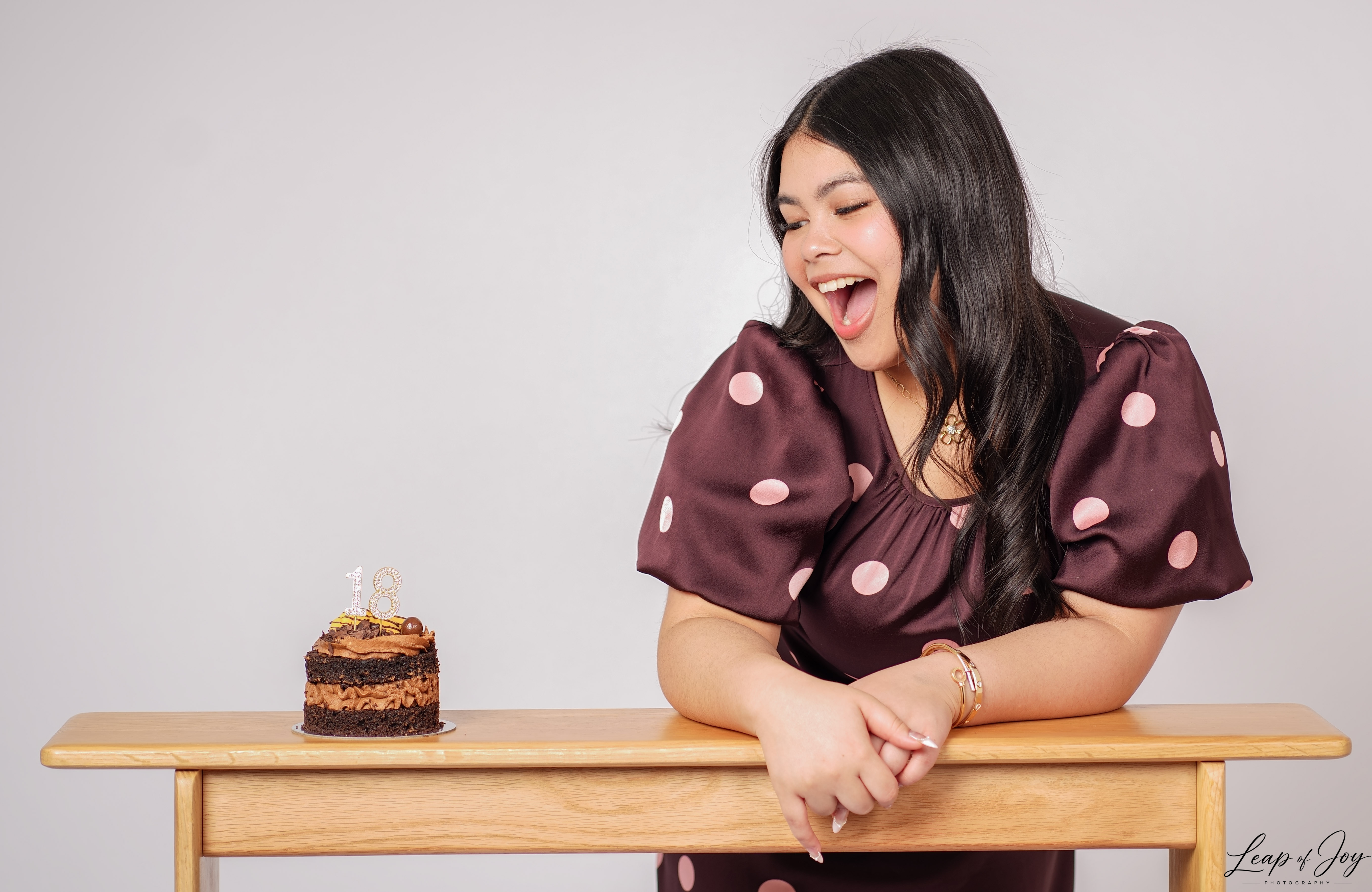 A young woman laughing with her birthday cake