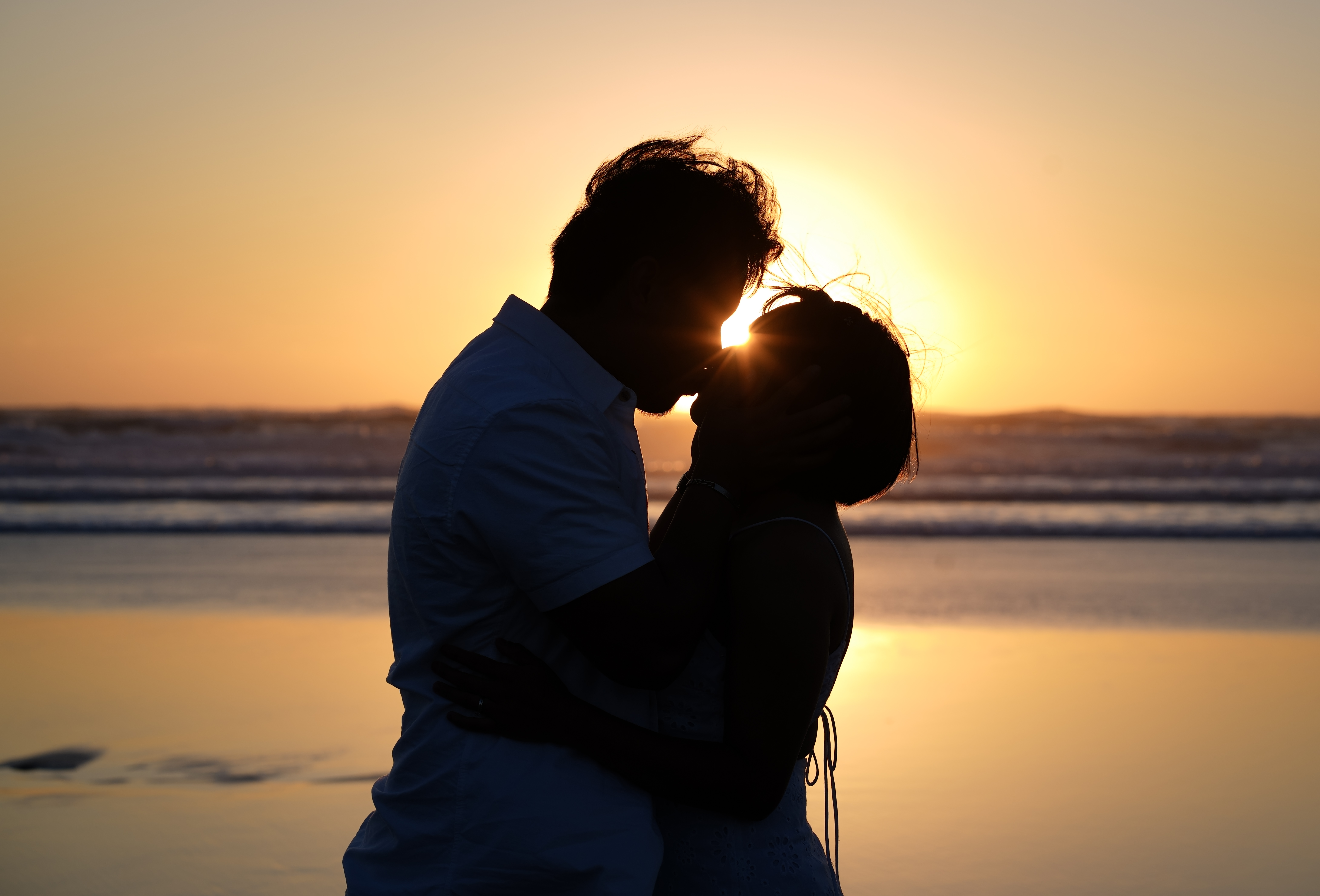 A couple silhouetted at sunset
