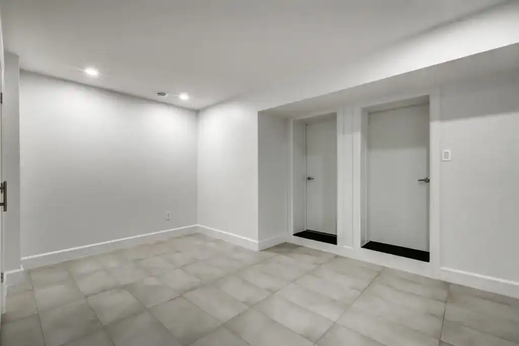 Legal basement living space by B&Y Reno Corp — finished walls, flooring, pot lights, and clean layout