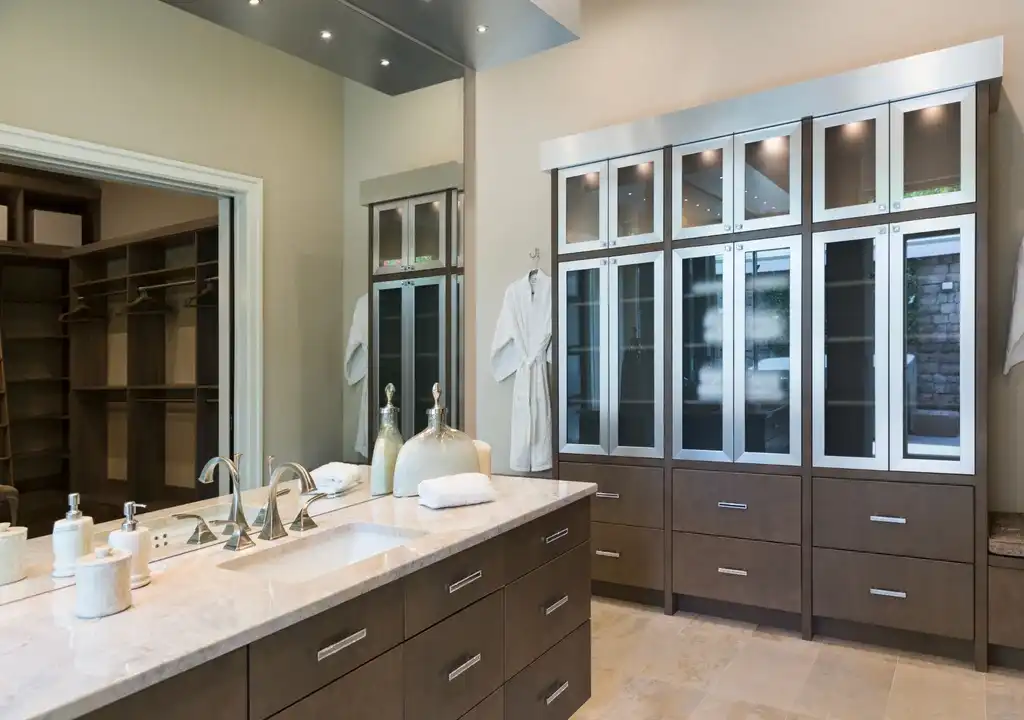 Custom dressing suite with vanity area, wardrobe storage, and luxury lighting