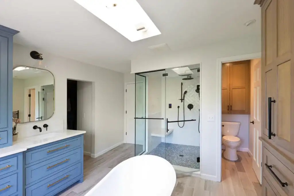 Bright luxury ensuite with glass shower, skylight, and freestanding tub