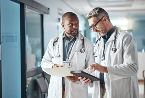 Two male doctors in medical uniforms representing busy professionals considering private matchmaking Two male doctors in medical uniforms representing busy professionals considering private matchmaking