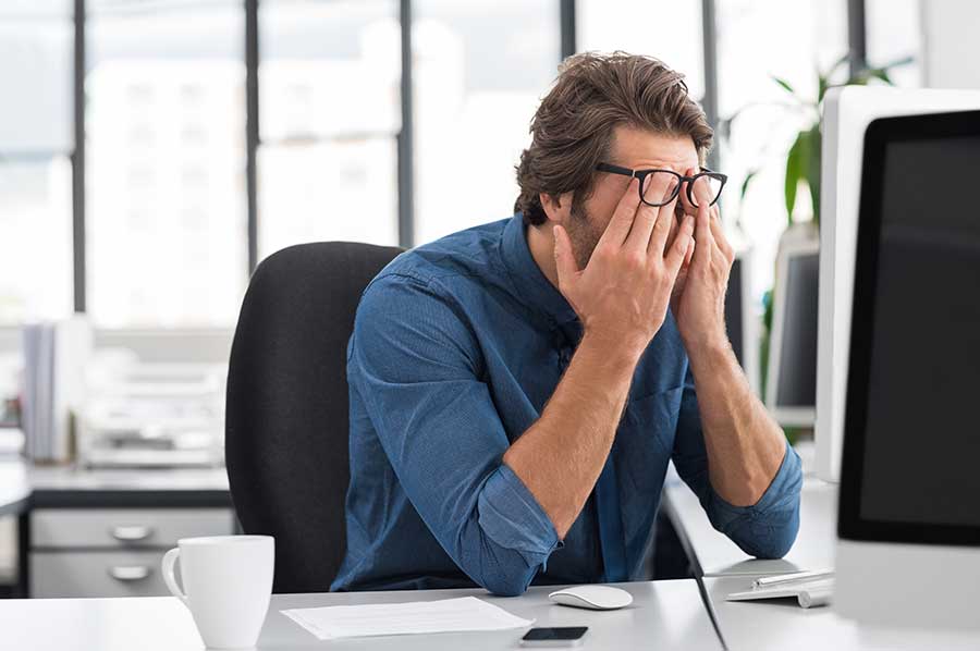 Founder rubbing his eyes at the office
