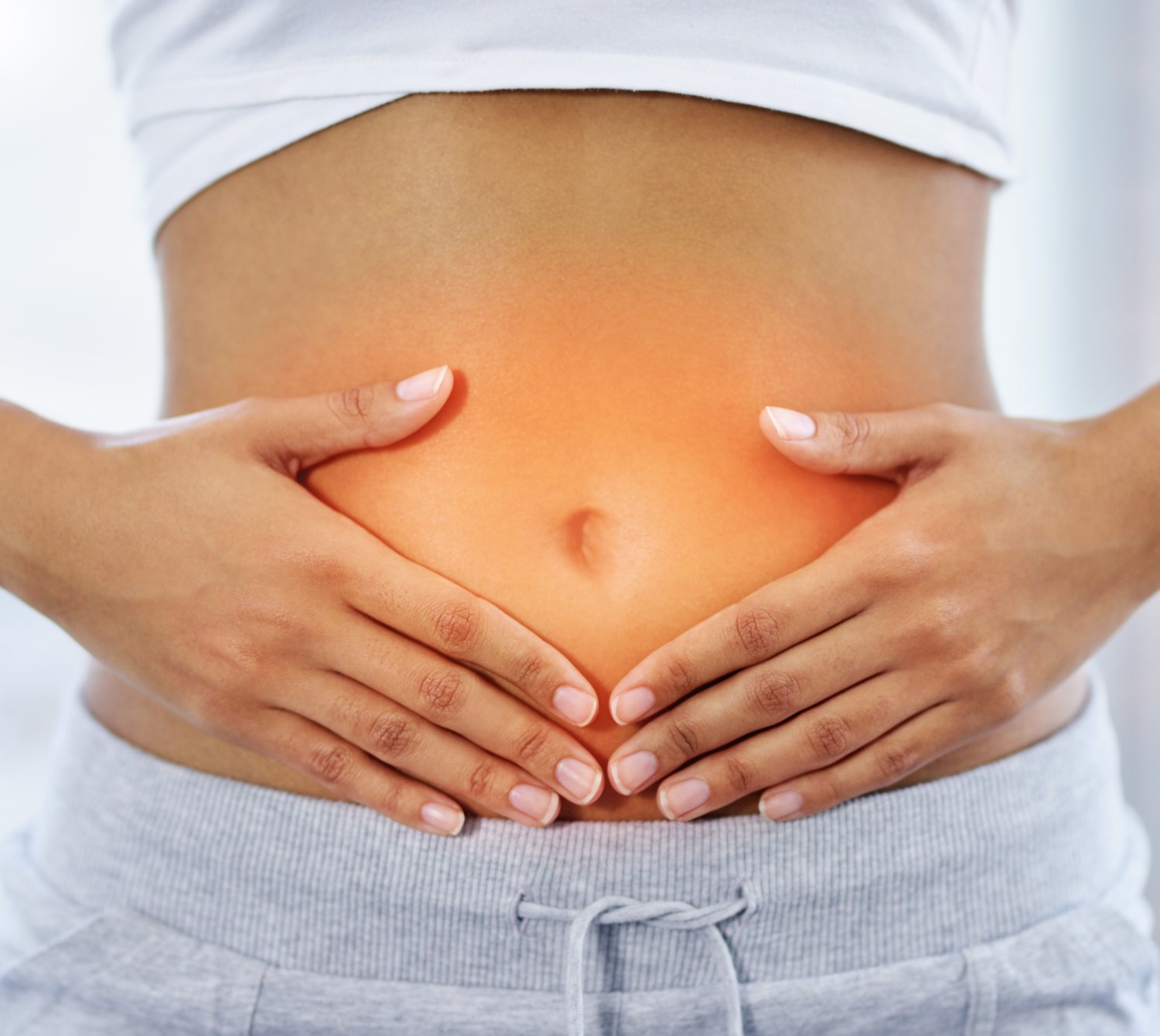 Woman resting both hands gently over her lower belly