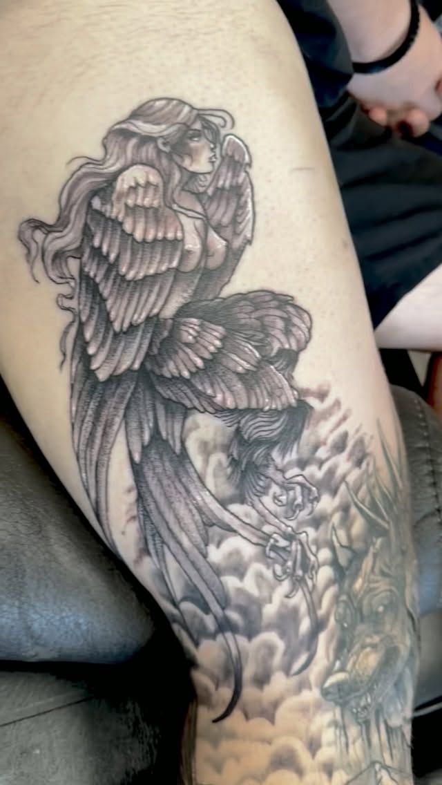 Black-and-grey harpy figure tattoo on the arm