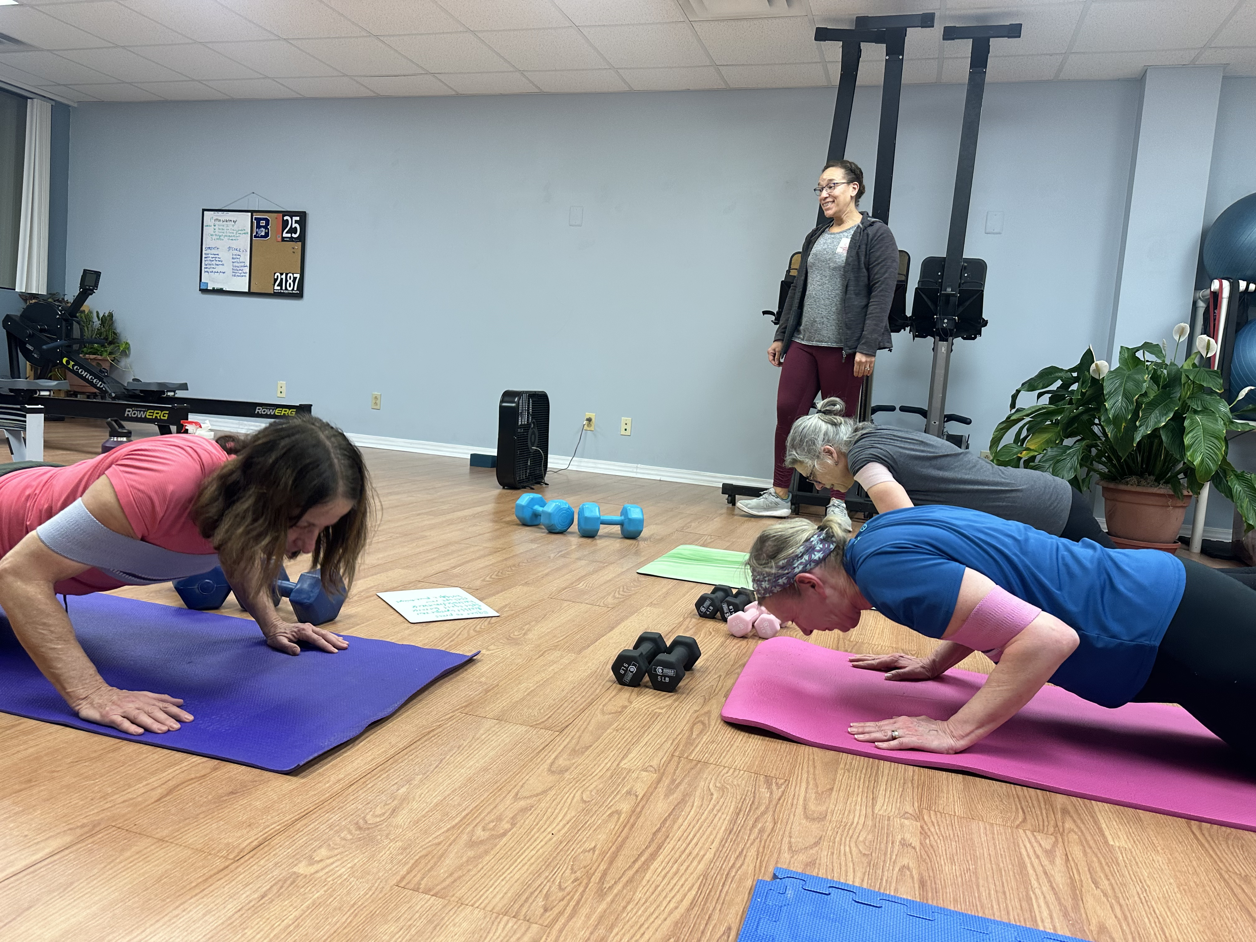 Coach observing and providing individualized technique feedback during a movement assessment at Rowing on the Square.
