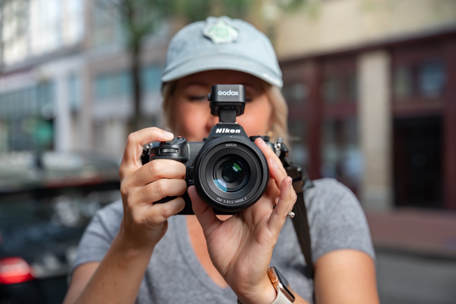 A photographer shooting a Nikon Z with a 50mm lens on a city street