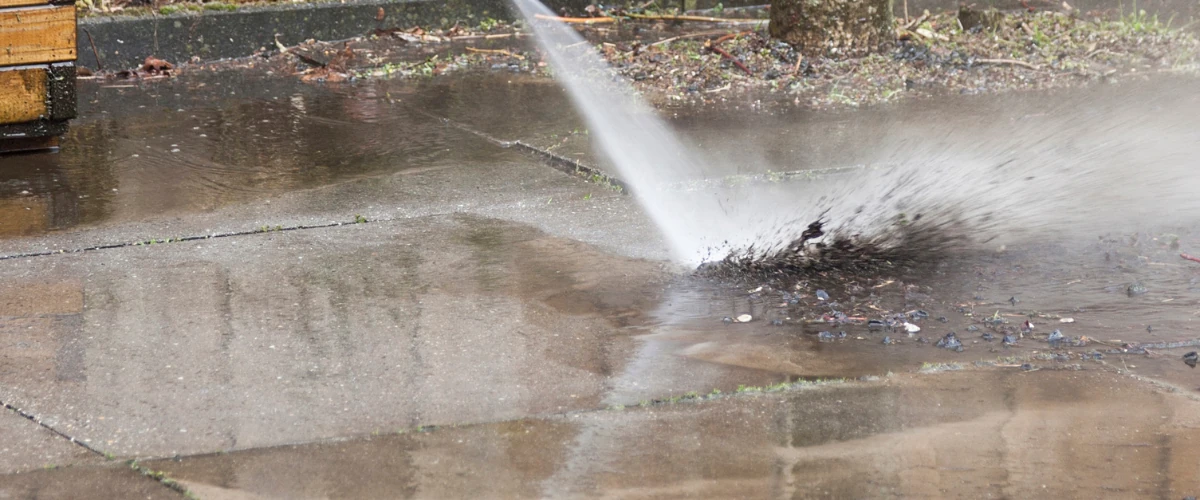 Power washing a driveway to remove dirt, grime, and debris buildup.