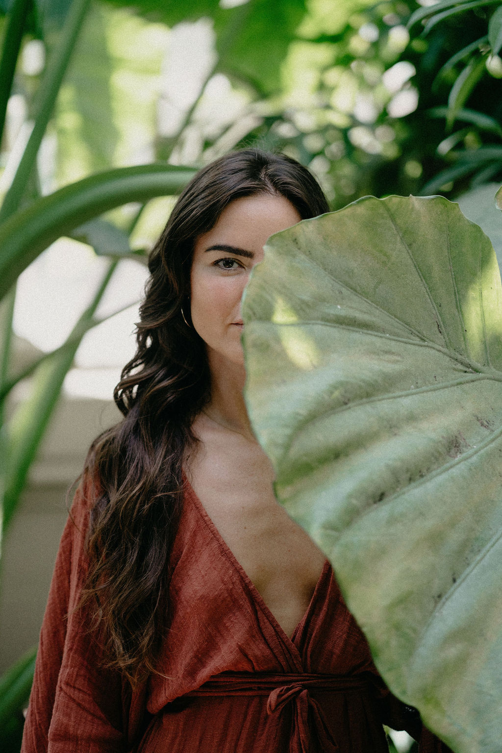 Débora Torrente junto a una hoja grande de planta tropical