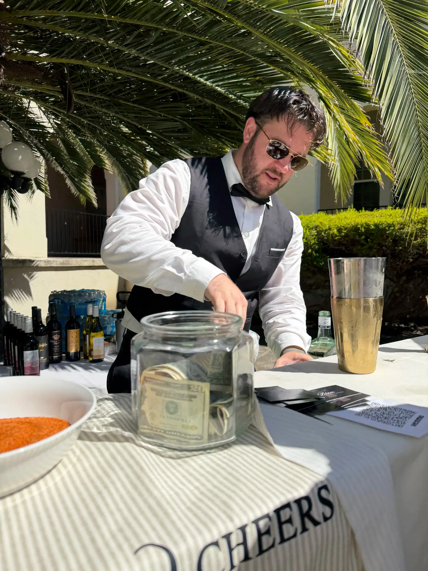 Dino mixing a cocktail at an outdoor Bay Area event, golden-hour light