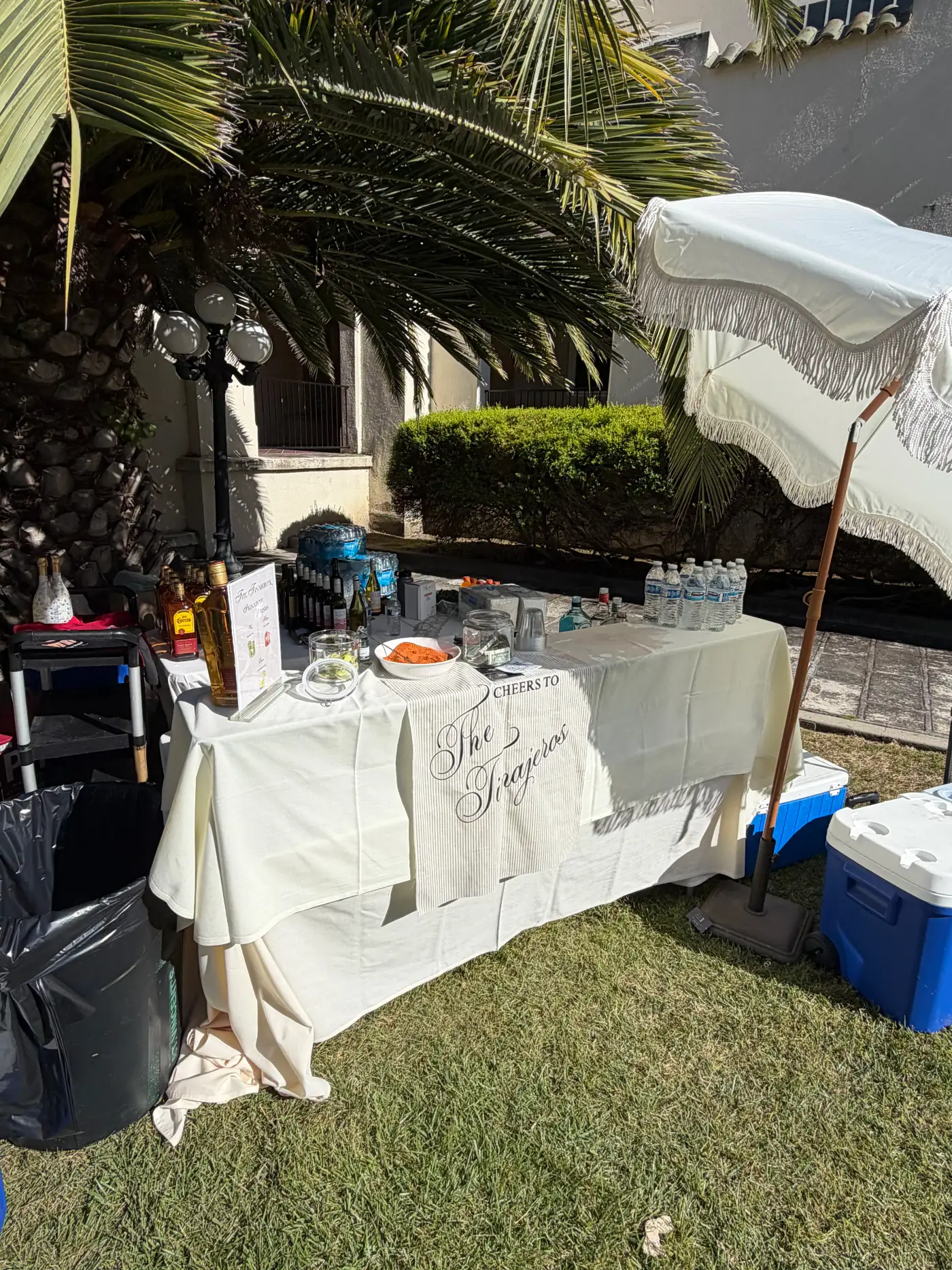 Full outdoor private-party bar setup with custom linens and umbrella
