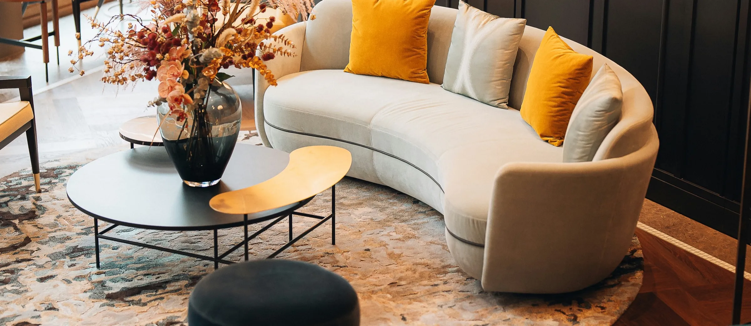 Salón de diseño con sofá curvo y cojines mostaza