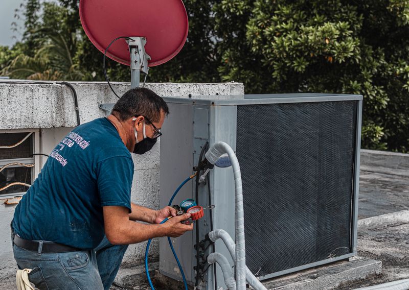 HVAC technician servicing an outdoor air conditioning unit. Illustrative stock photo.