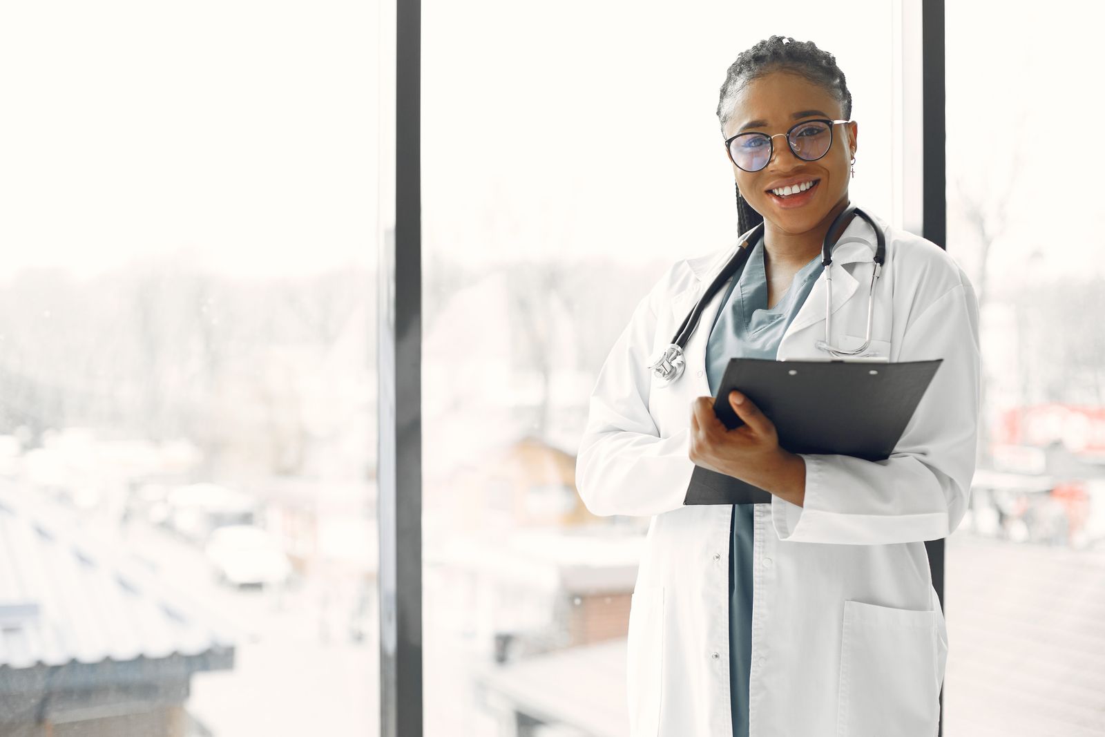 A primary-care physician with a clipboard in a bright office — illustrative stock photo