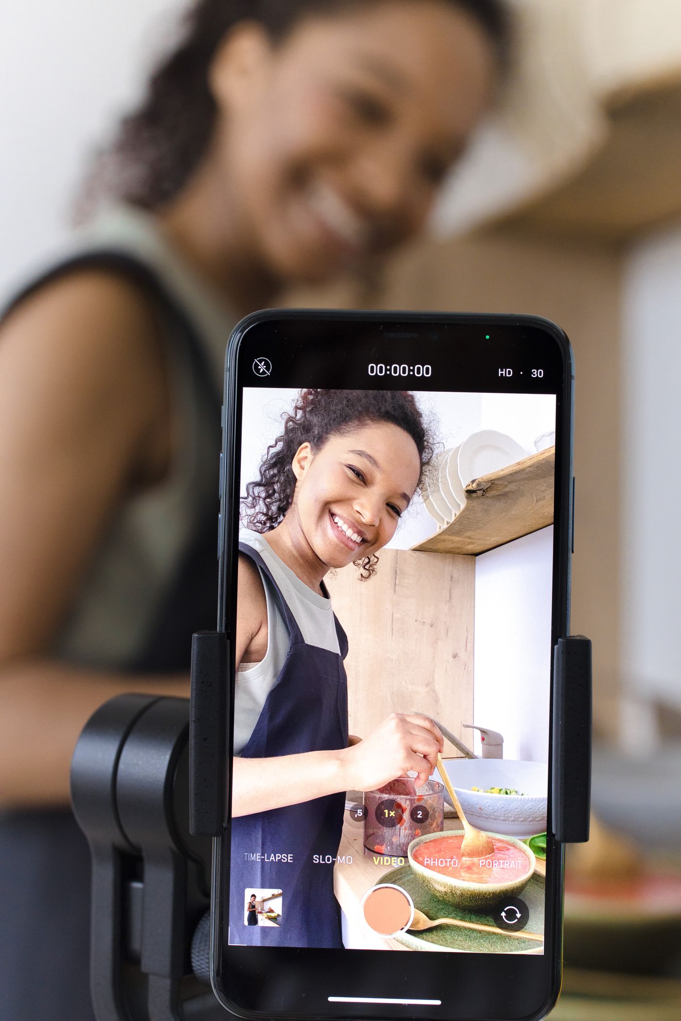 Phone mounted on a gimbal, screen showing an in-progress recording with the camera app's timer and controls visible — illustrative, not real client footage.