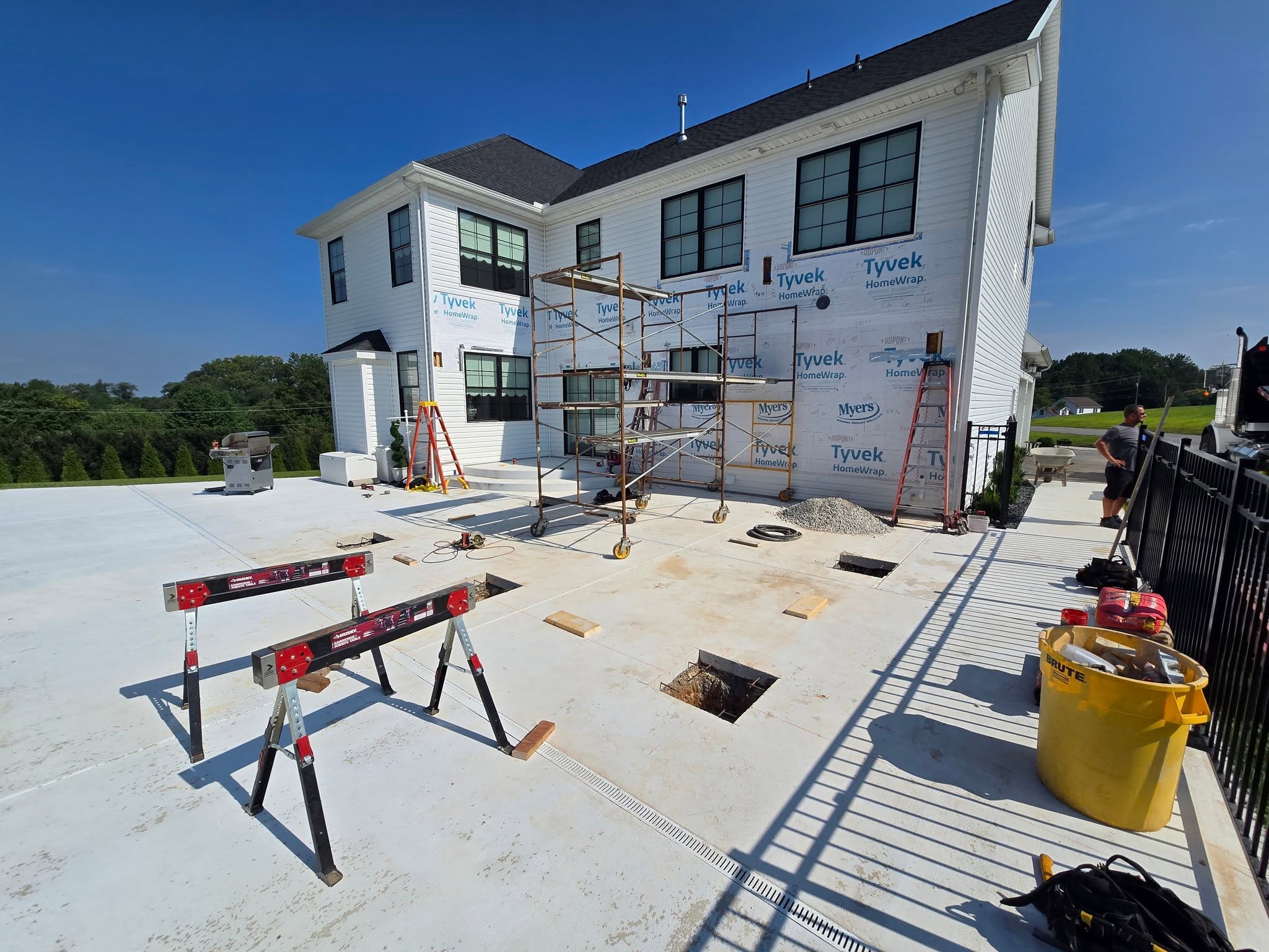 Custom home under construction with black windows and tools on site