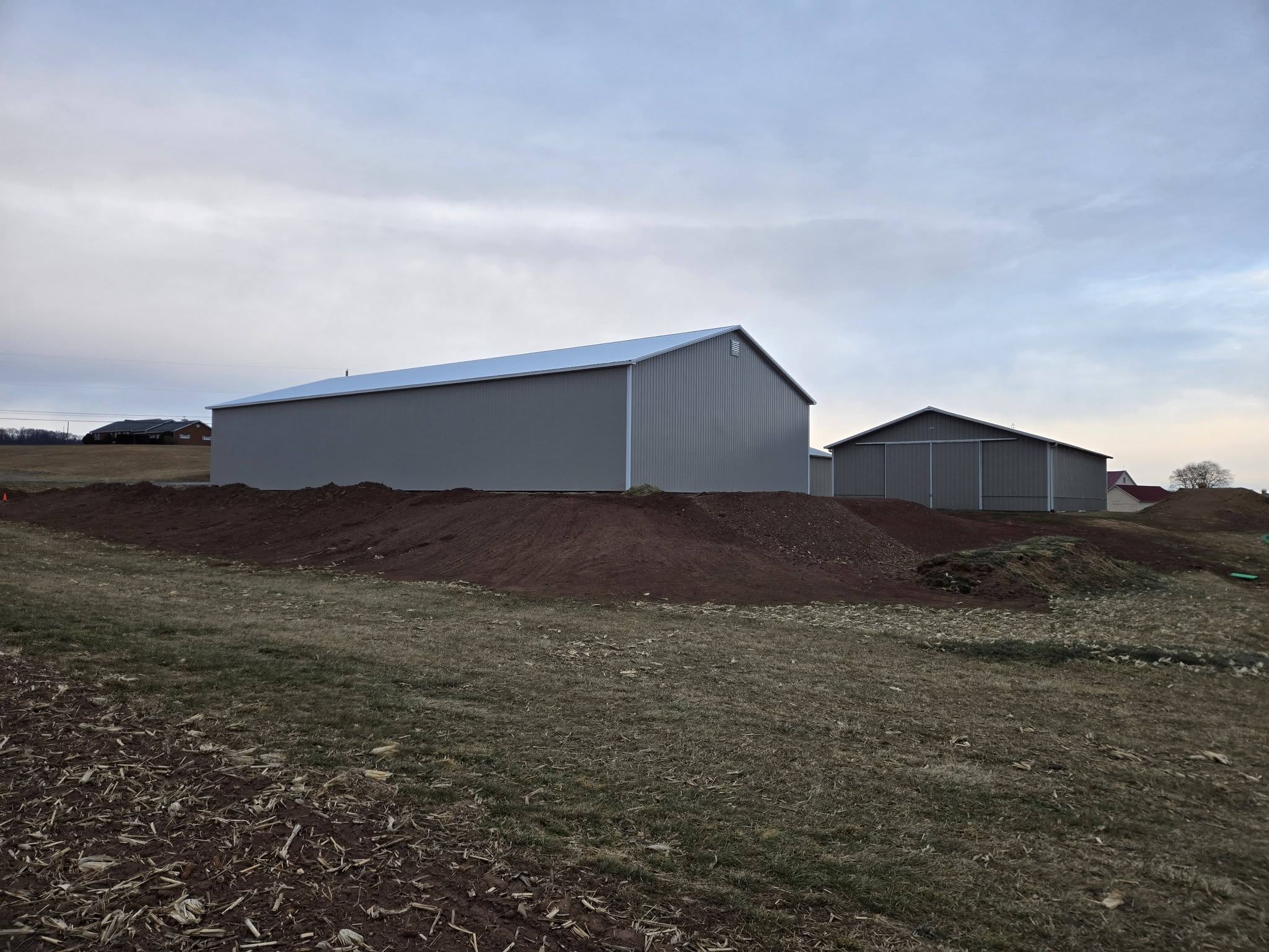 Grey and white metal building erected by Harcon Services on a graded lot