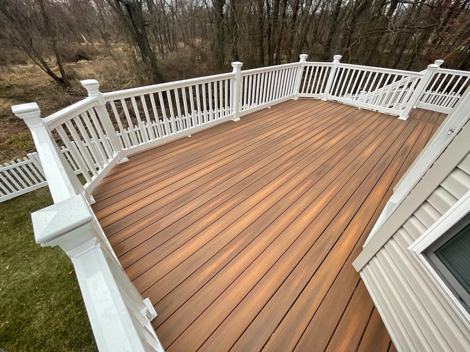 Custom composite deck with railings built onto a Wisconsin home