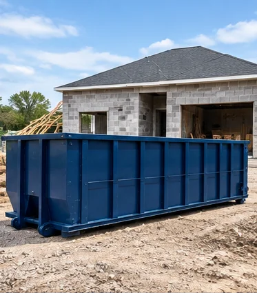 Long roll-off dumpster beside a new home under construction