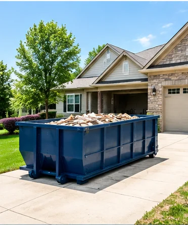 Loaded roll-off dumpster on a concrete driveway outside a suburban home