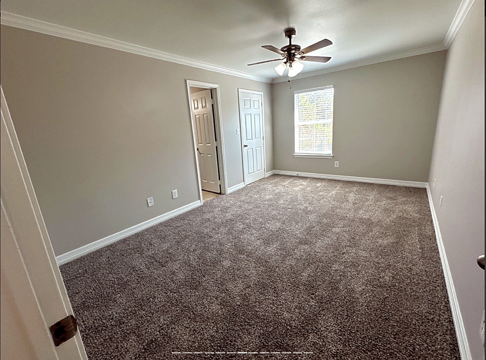 Carpeted bedroom with a ceiling fan and window in an apartment at Grace Pointe, Longview, TX