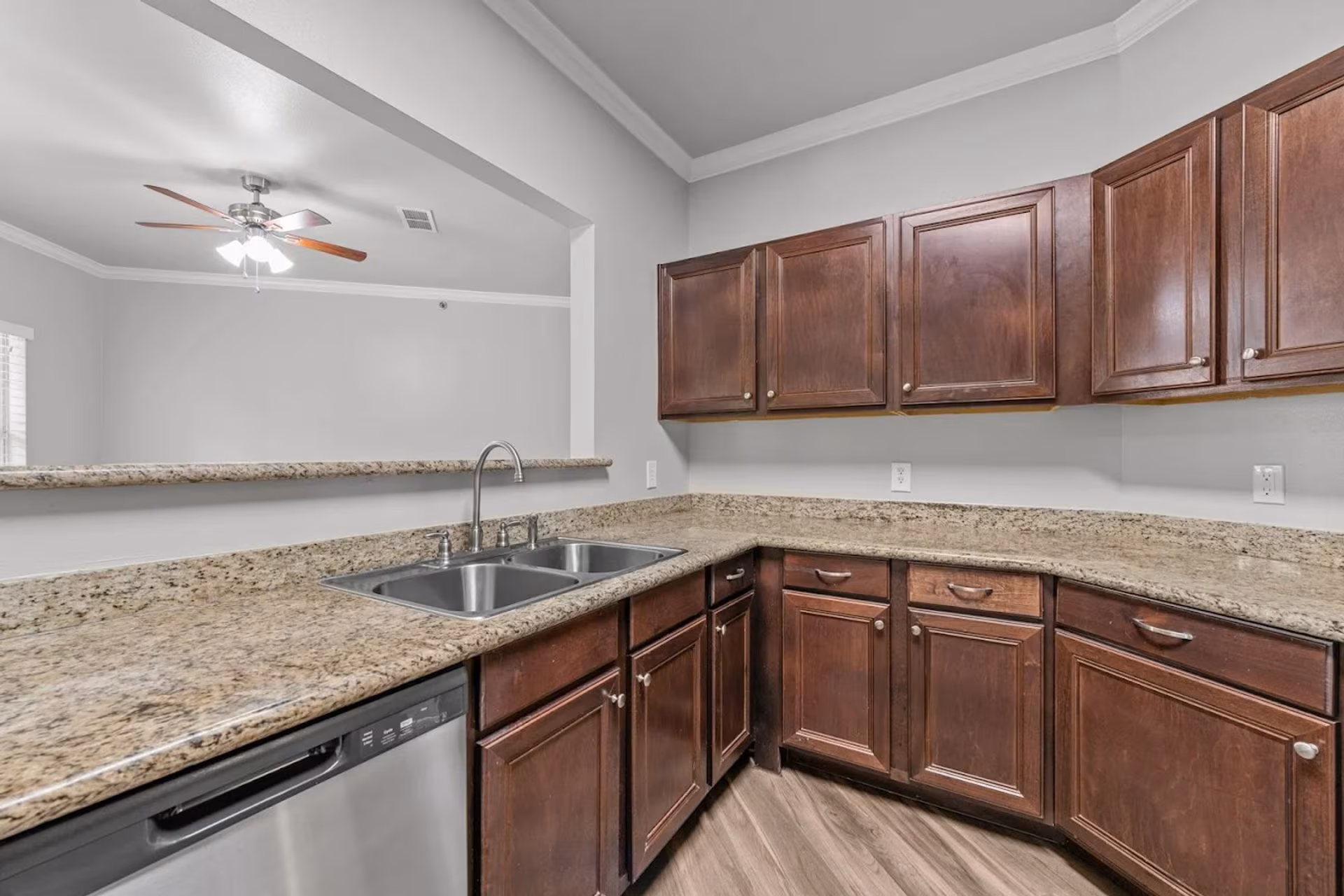 Kitchen with granite countertops, dark wood cabinetry and a stainless dishwasher