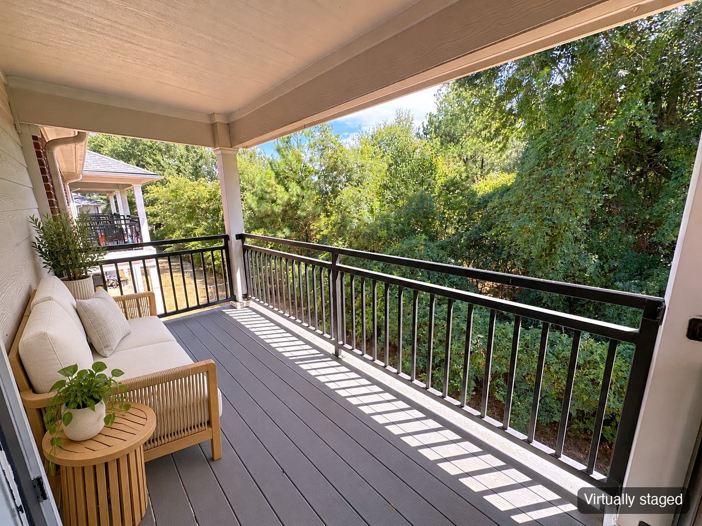 Covered balcony overlooking trees (virtually staged)