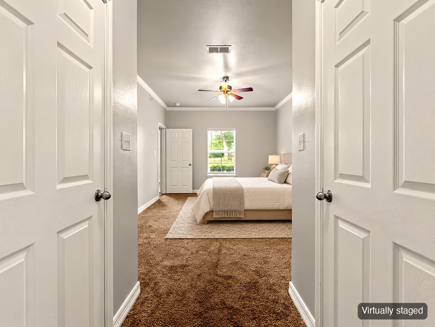 Bedroom seen through double doors (virtually staged)