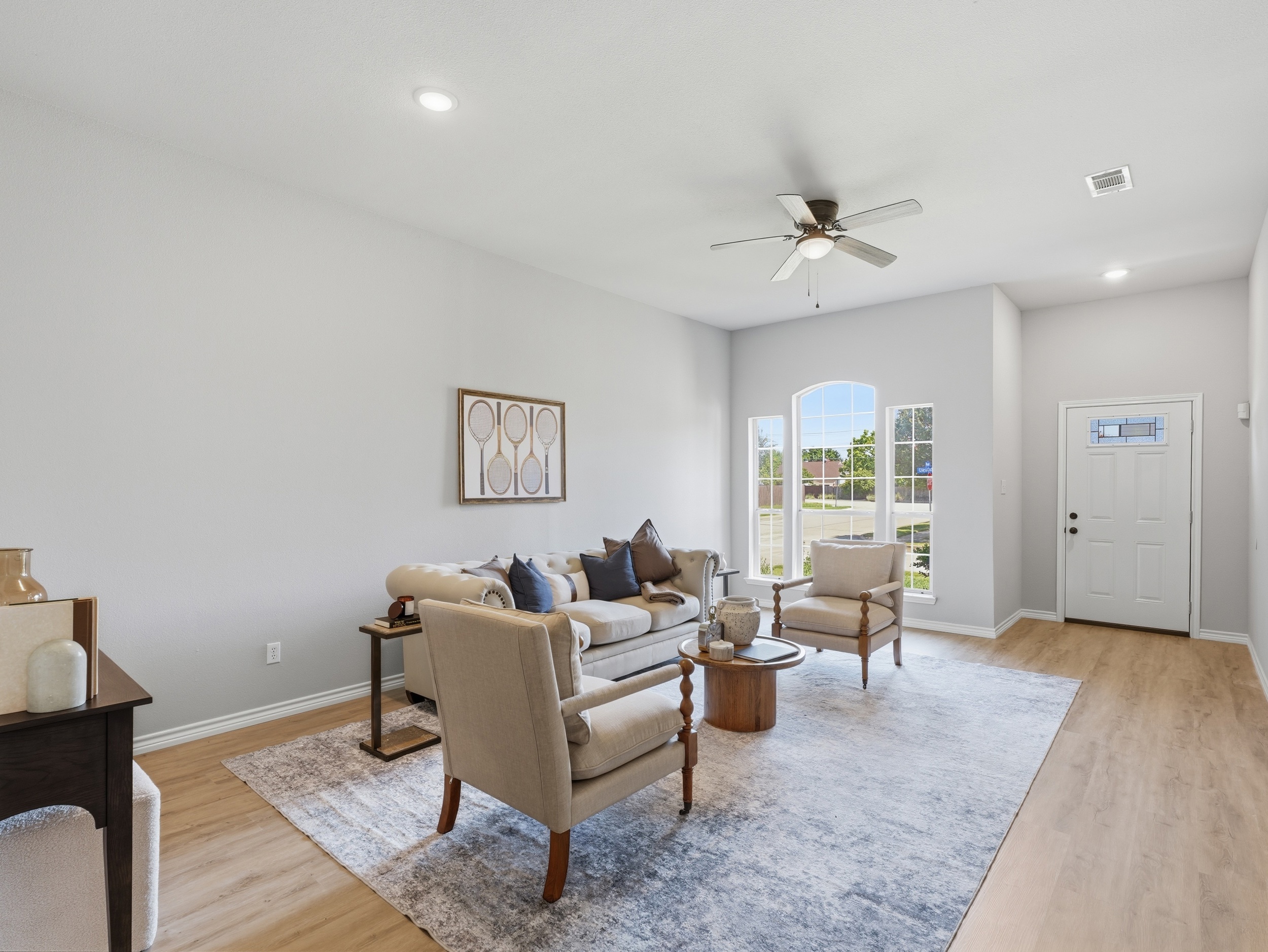 Same living room photographed by Kaptiv Media — true colour, fan stopped, window holding its view