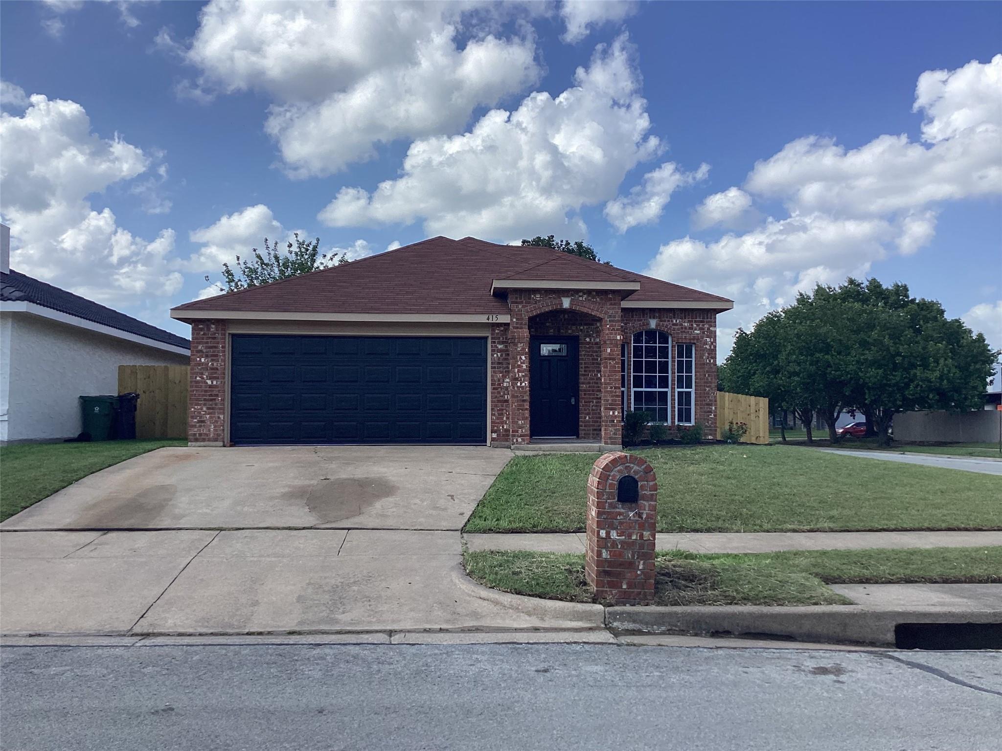 415 Cross Cut Drive front exterior in the previous listing — off-centre and tilted, shot in flat midday light