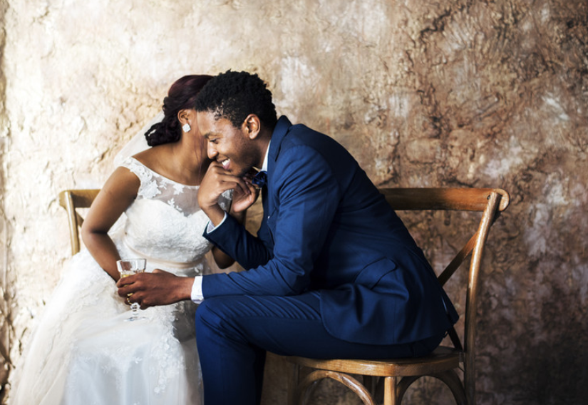 happy black couple whispering at wedding