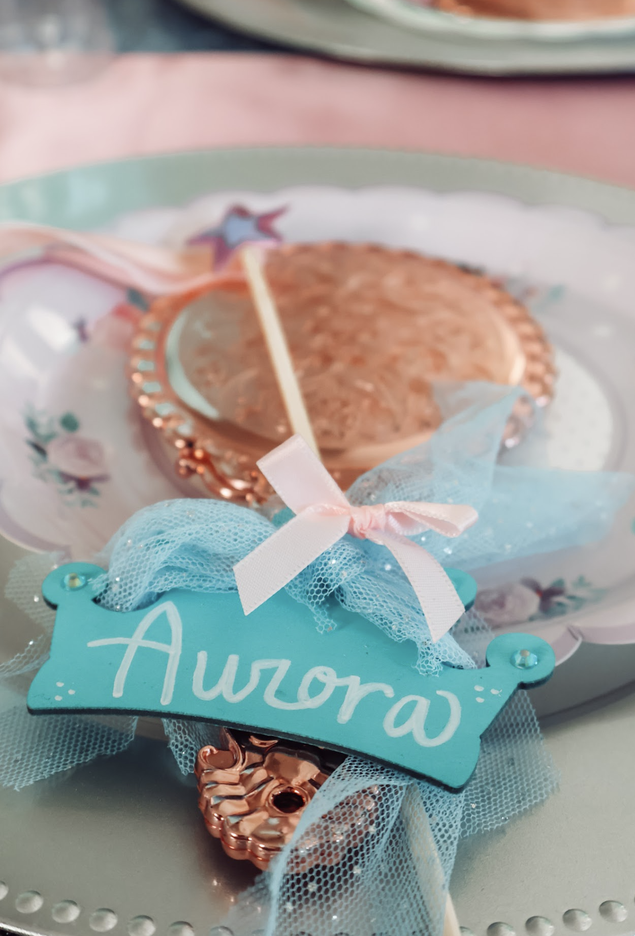 Princess party place setting with a pink ribbon, blue tulle and decorative plate