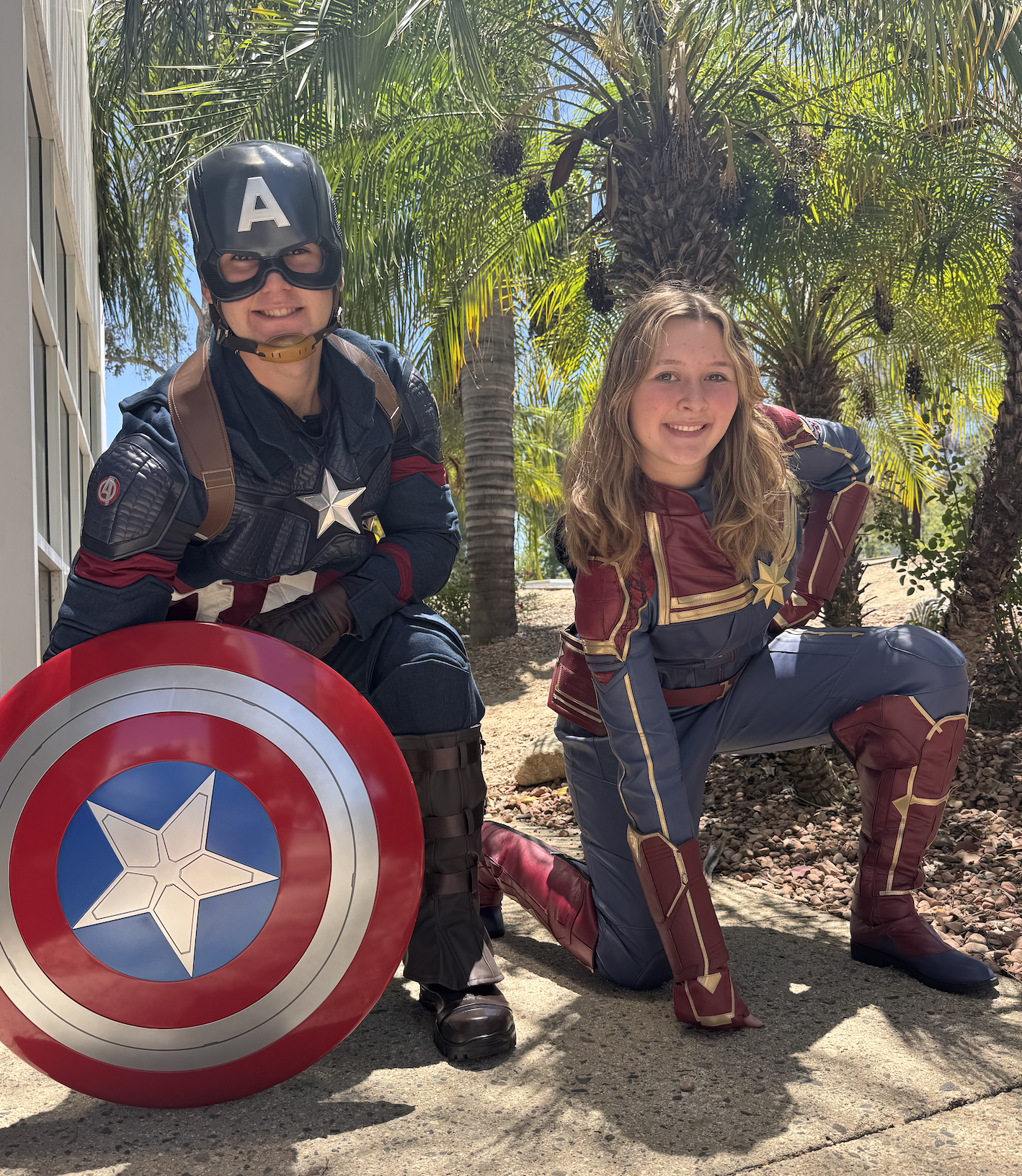 Captain America and Captain Marvel posing together outdoors